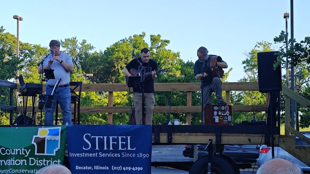 Broken Brogue performing on stage in a park.